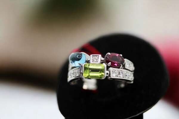 Añillo de oro blanco de 18k, Marca: BVLGARI, Modelo: ALLEGRA con piedras de colores: peridoto, topacio, tourmaline rosa y diamantes.