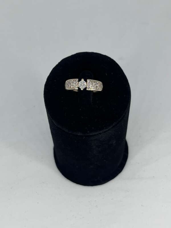 Anillo de oro de 14 k con diamante central de 0.30 cts y diamantes laterales