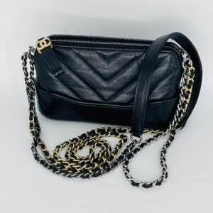 Elegancia atemporal y diseño icónico se unen en el Mini bolso de hombro y cruzado Chanel Gabrielle, confeccionado en piel de cordero negra de alta calidad. Este exclusivo modelo destaca por sus herrajes de cadena mixtos en tono dorado y plateado, que aportan versatilidad y un estilo sofisticado que se adapta tanto a looks casuales como de ocasión. Su diseño estructurado y ligero ofrece comodidad y funcionalidad, permitiendo llevarlo al hombro, cruzado o incluso a la cintura. Como pieza emblemática de la Maison Chanel, el bolso Gabrielle se ha convertido en un símbolo de lujo moderno, refinamiento y personalidad. Perfecto para quienes buscan un complemento exclusivo, elegante y auténtico.