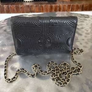 Bolso Chanel Camellia Wallet on Chain en cuero negro con herrajes plateados